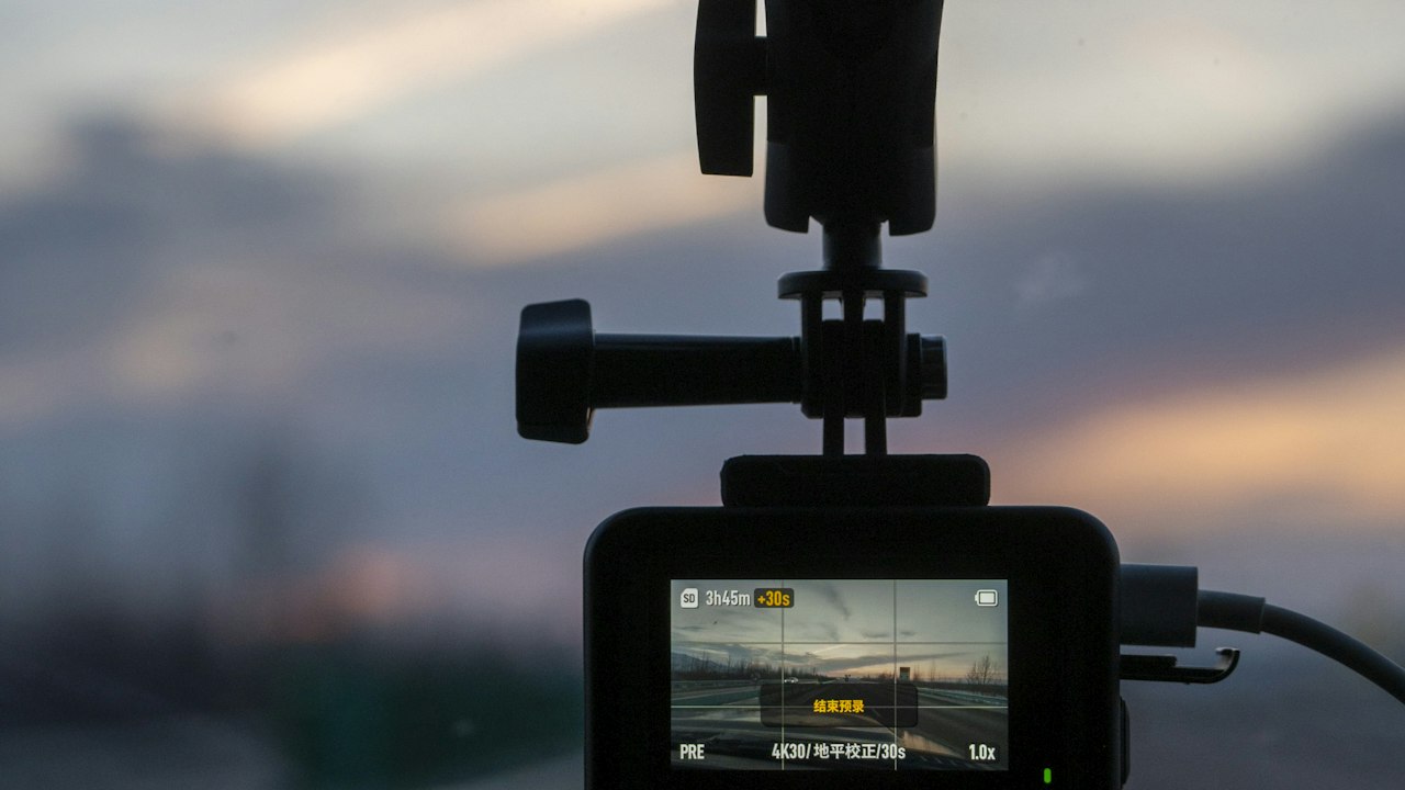 A camera mounted on a car windscreen at sunset, looking out over the road